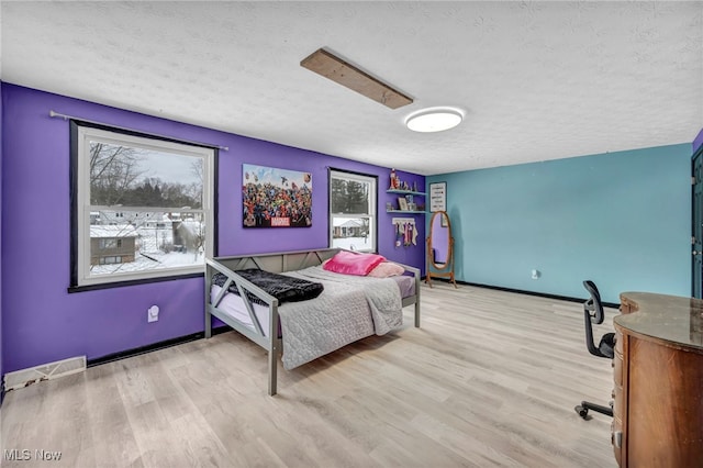 bedroom featuring light wood-type flooring and a textured ceiling