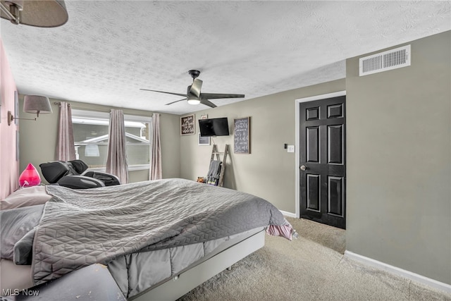 carpeted bedroom featuring ceiling fan and a textured ceiling