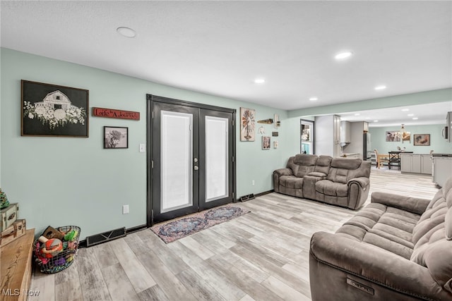 living room with french doors and light hardwood / wood-style flooring