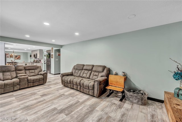 living room with light wood-type flooring and an inviting chandelier