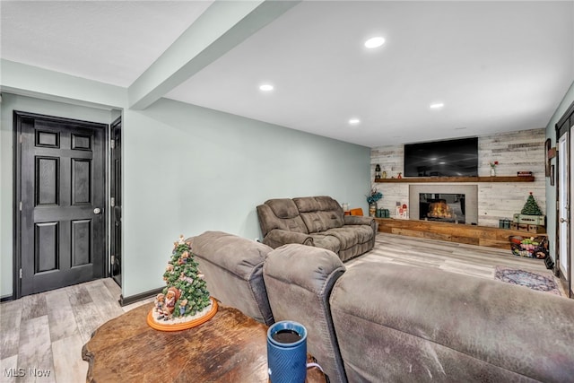 living room with a fireplace, wood-type flooring, wooden walls, and beamed ceiling