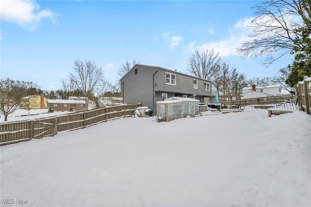 snow covered house featuring an outdoor structure