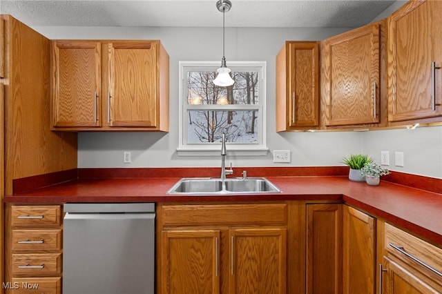 kitchen with pendant lighting, dishwasher, sink, and a textured ceiling