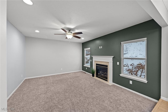 unfurnished living room with carpet flooring and ceiling fan