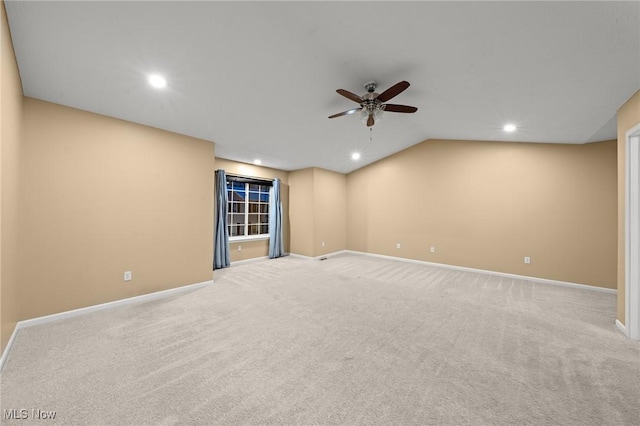 unfurnished room with ceiling fan, light carpet, and vaulted ceiling