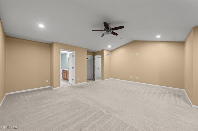 carpeted spare room featuring ceiling fan and lofted ceiling