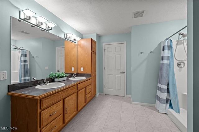 bathroom featuring a textured ceiling, vanity, and curtained shower