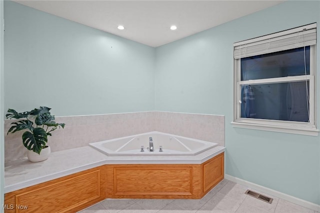 bathroom with tile patterned floors and a bath