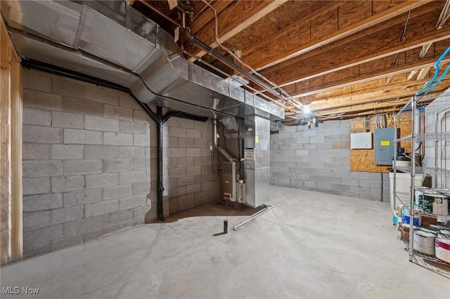 basement featuring electric panel and heating unit