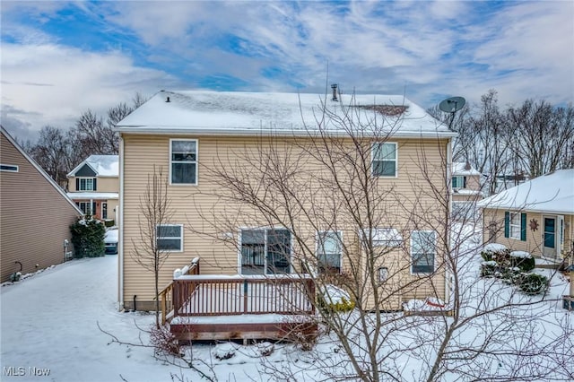 snow covered rear of property featuring a wooden deck