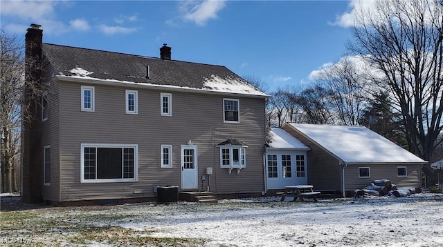 snow covered rear of property with central air condition unit