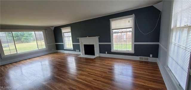 unfurnished living room with hardwood / wood-style floors and a healthy amount of sunlight