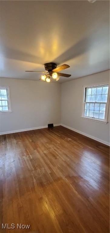 empty room with ceiling fan and dark hardwood / wood-style flooring