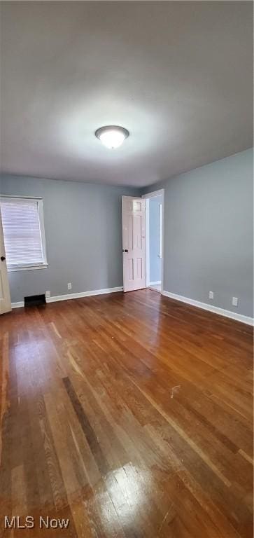 unfurnished room with dark wood-type flooring