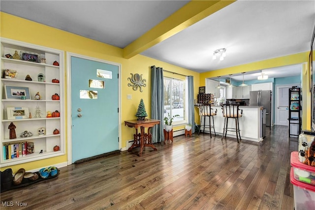 foyer entrance with dark hardwood / wood-style flooring and beamed ceiling