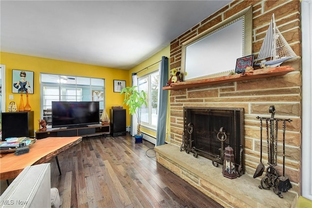 living room with hardwood / wood-style flooring and a brick fireplace