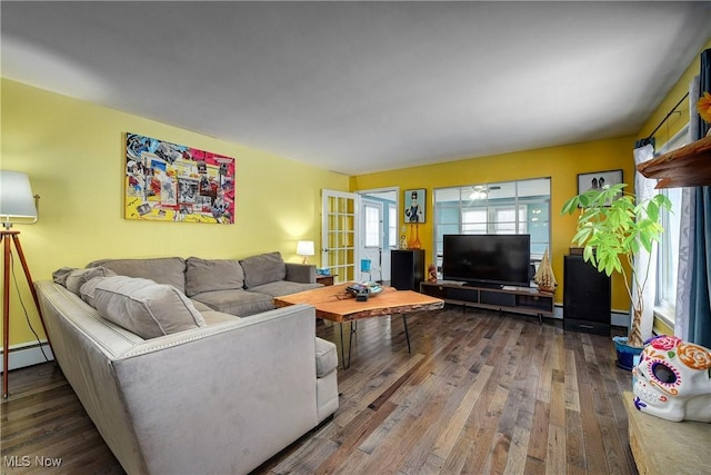 living room with ceiling fan, wood-type flooring, and a baseboard heating unit