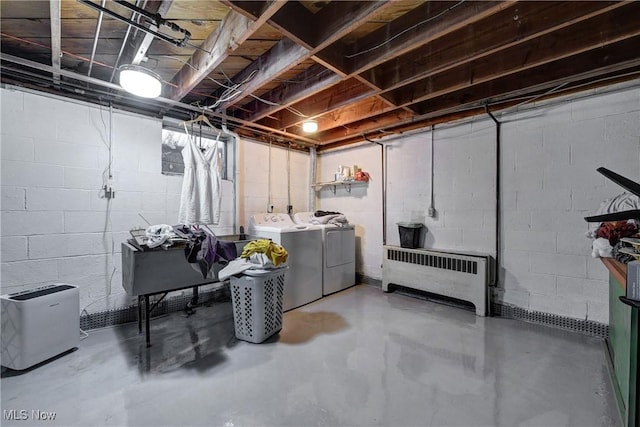 basement featuring radiator and washer and clothes dryer