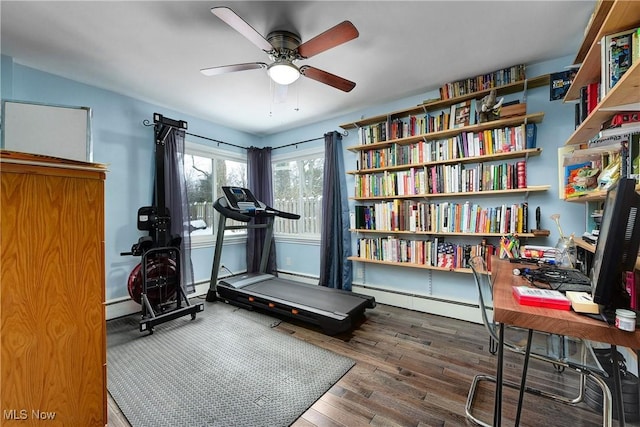 workout area with wood-type flooring, ceiling fan, and a baseboard heating unit