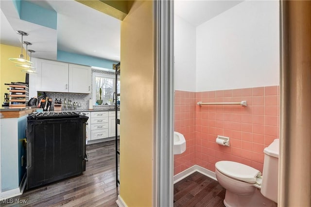 bathroom with vanity, toilet, wood-type flooring, and tile walls