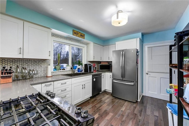 kitchen with white cabinets, dark hardwood / wood-style flooring, sink, and stainless steel appliances