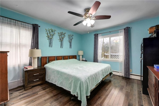 bedroom featuring ceiling fan, dark wood-type flooring, and a baseboard heating unit