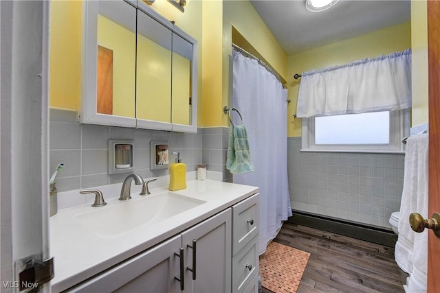 bathroom featuring decorative backsplash, vanity, hardwood / wood-style flooring, and tile walls