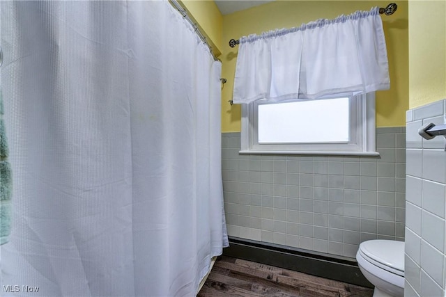 bathroom featuring tile walls and toilet