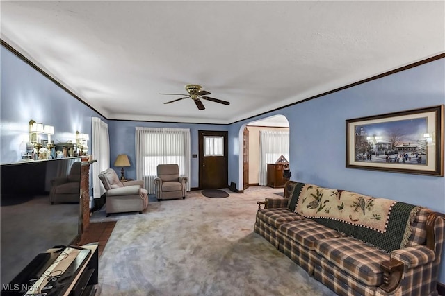 carpeted living room with ceiling fan and crown molding