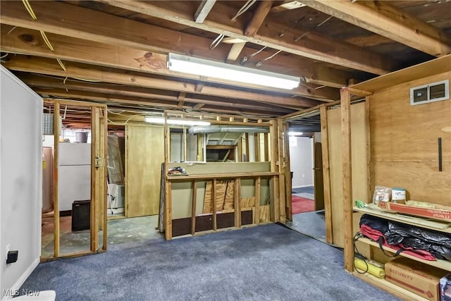 basement featuring white fridge and dark carpet