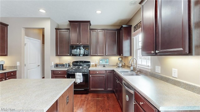 kitchen featuring black appliances, dark hardwood / wood-style floors, and sink