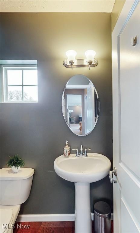 bathroom with hardwood / wood-style floors and toilet