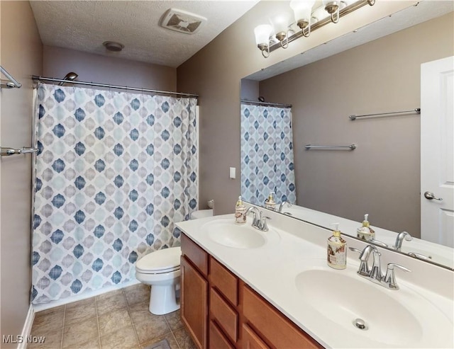 bathroom featuring vanity, a textured ceiling, and toilet