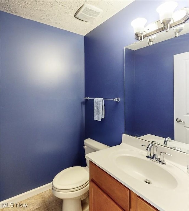 bathroom featuring vanity, a textured ceiling, tile patterned floors, and toilet