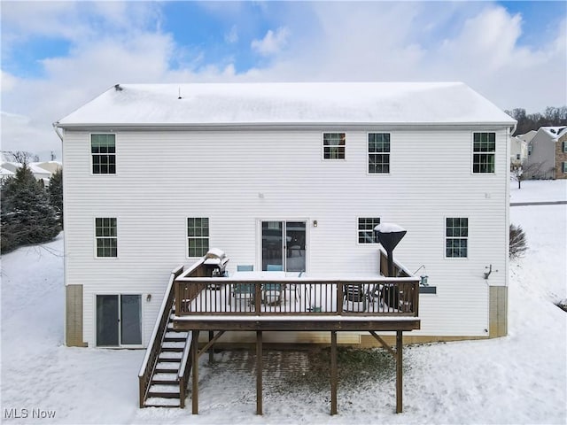 snow covered house featuring a deck