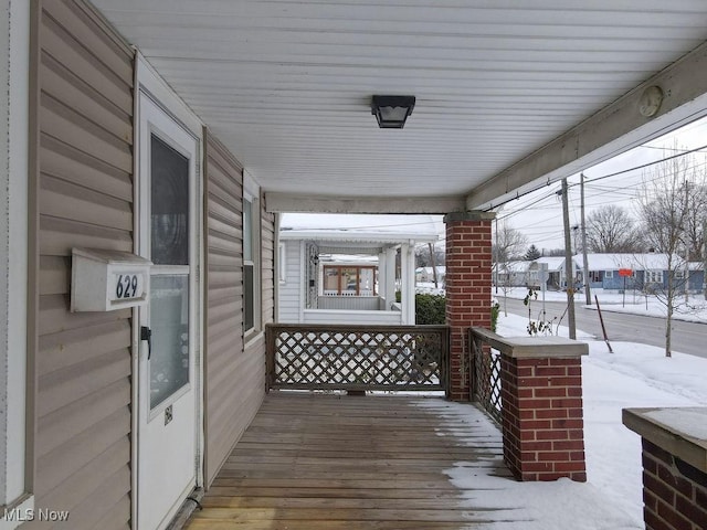 snow covered deck with covered porch