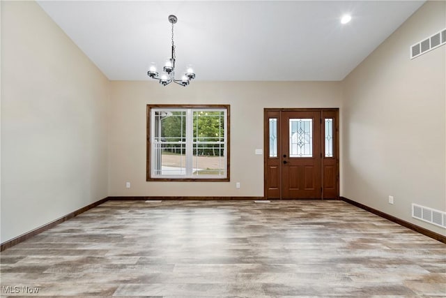 foyer with light hardwood / wood-style flooring and a notable chandelier