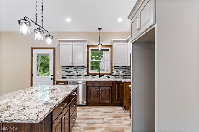 kitchen with dishwasher, a center island, sink, decorative backsplash, and dark brown cabinets