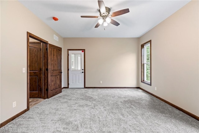 carpeted empty room featuring ceiling fan