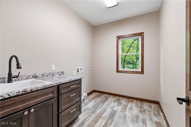 laundry room with sink, cabinets, hookup for an electric dryer, hookup for a washing machine, and light hardwood / wood-style floors