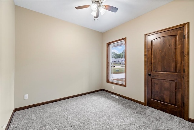 carpeted spare room featuring ceiling fan