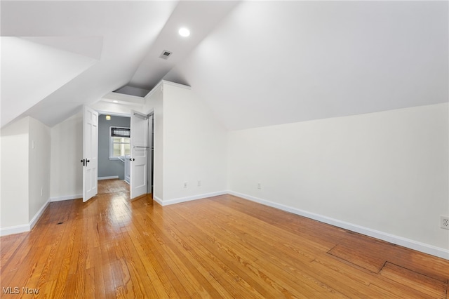 bonus room with light hardwood / wood-style flooring and vaulted ceiling