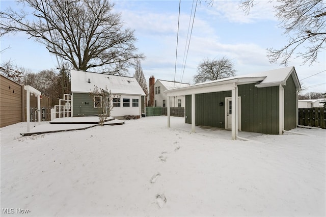 view of snow covered back of property