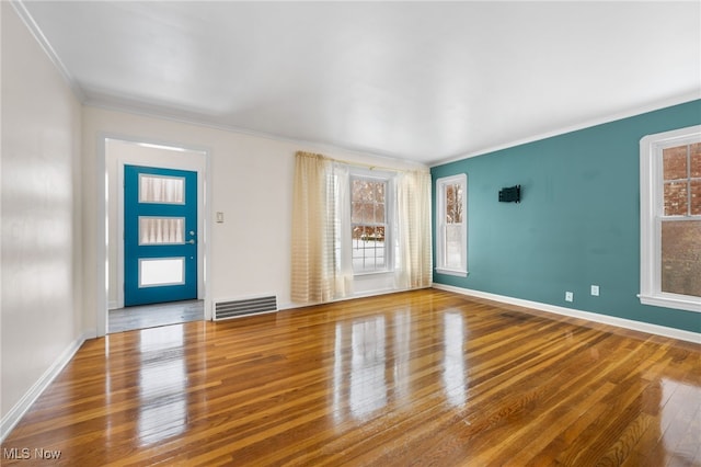 foyer featuring plenty of natural light, hardwood / wood-style floors, and ornamental molding