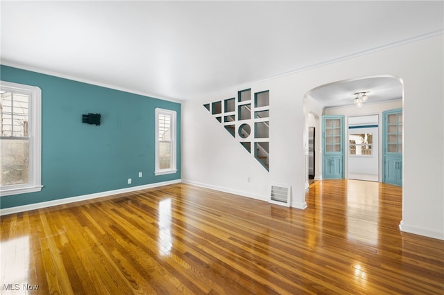 spare room featuring wood-type flooring and a notable chandelier