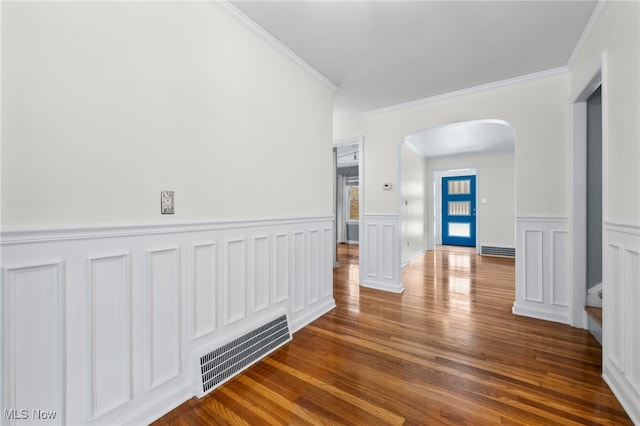 hallway featuring dark hardwood / wood-style flooring, crown molding, and a baseboard radiator