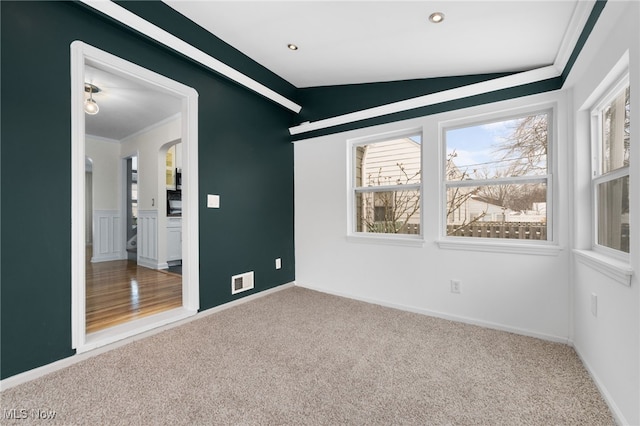 carpeted spare room featuring a wealth of natural light and lofted ceiling