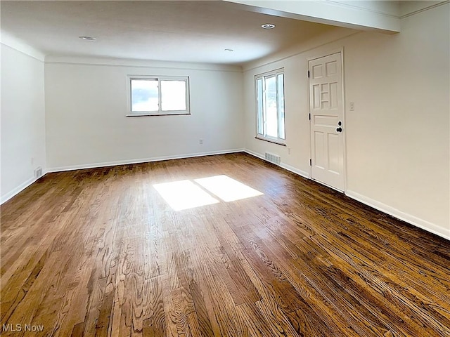 unfurnished room featuring beamed ceiling and wood-type flooring