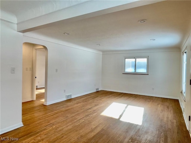 unfurnished room featuring hardwood / wood-style flooring, crown molding, and a wealth of natural light