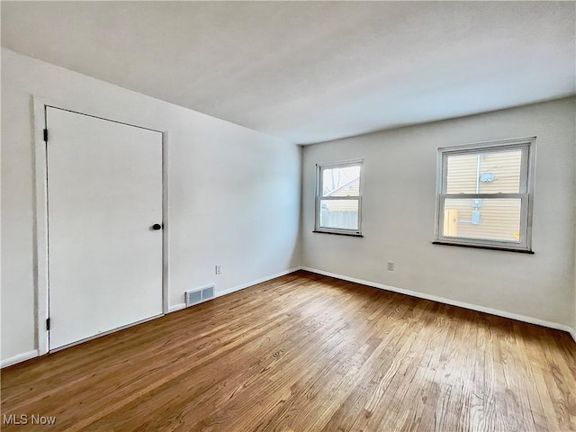 unfurnished room with hardwood / wood-style floors